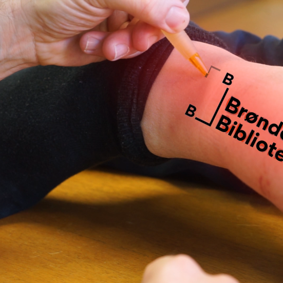 Brønderslev Biblioteks logo, tatoveret på herreankel.