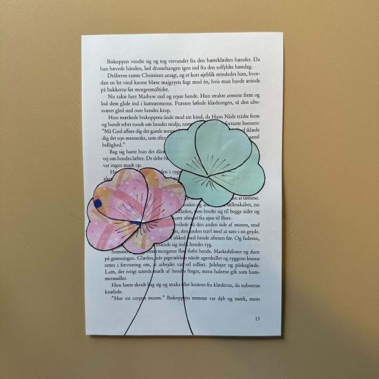 Collage af papirblomster på en bogside