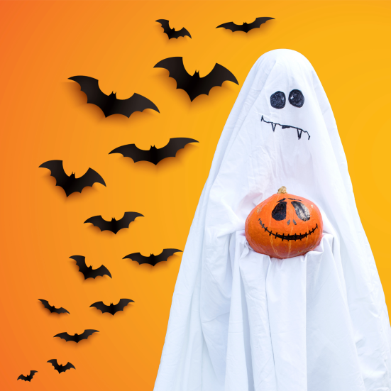 Et halloweenspøgelse foran en flok flagermus
