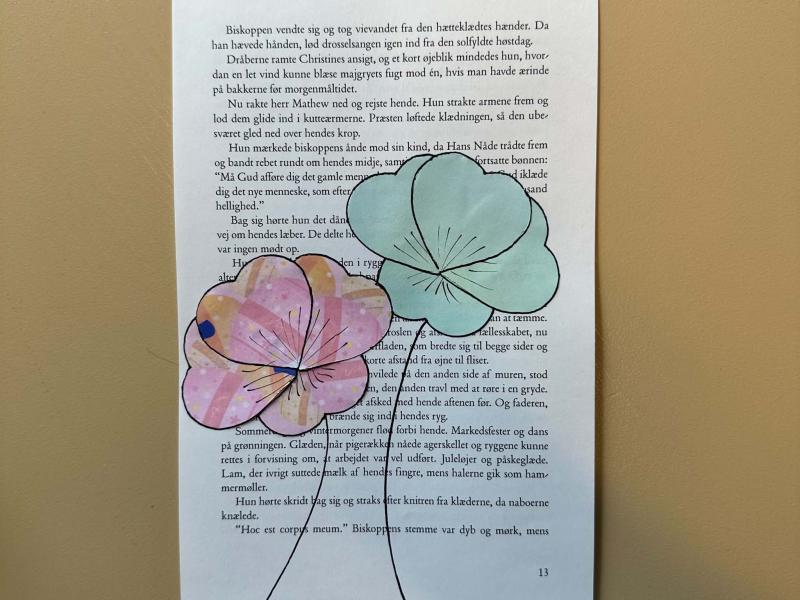 Collage af papirblomster på en bogside
