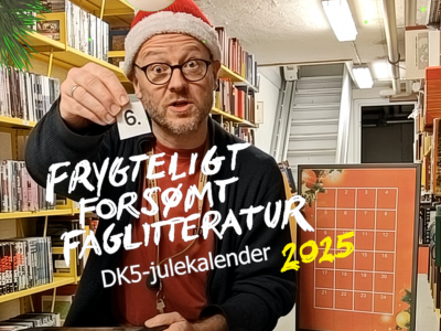 Formidler Hans Wendelboe Bøcher med nissehuse viser en lap papir med tallet 6. Foran ham står titlen på Facebook-julekalenderen: "Frygteligt Forsømt Faglitteratur - DK5-julekalender 2025".
