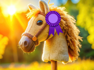 Foto af en kæphest med en præmieroset fæstnet til hovedet