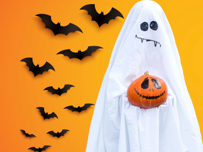 Et halloweenspøgelse foran en flok flagermus