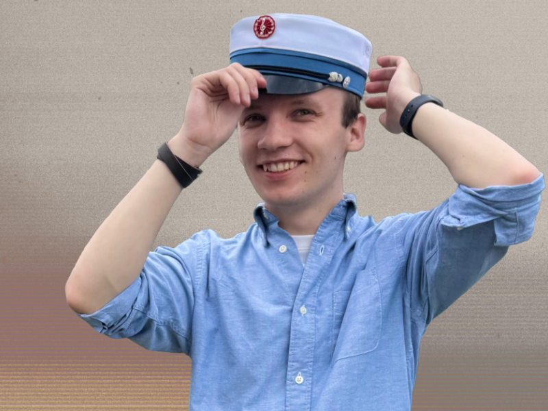 Jakob Manton i blå skjorte med studenterhue på