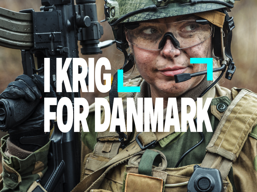 Kvindlig soldat i kampuniform med maskingevær og teksten: "I krig for Danmark"