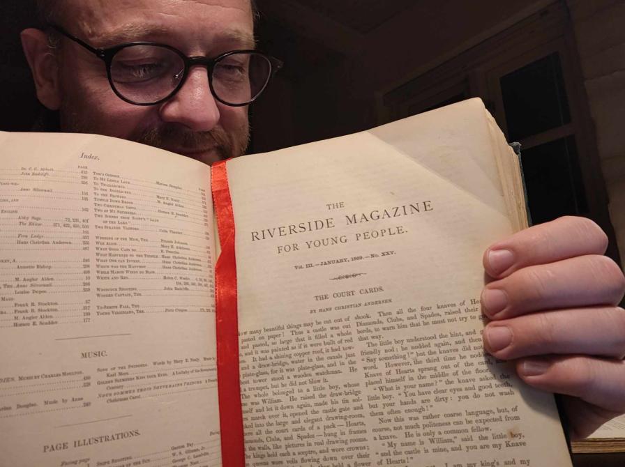 Formidler Hans Wendelboe Bøcher med førsteudgaven fra 1869 af H. C. Andersen-eventyret "The Court Cards".