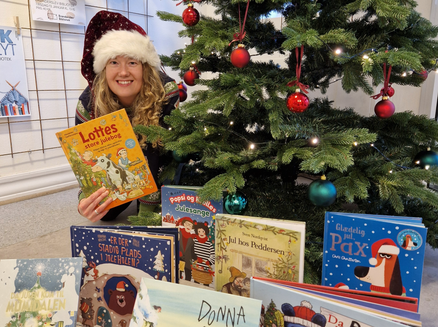 Rikke sidder ved juletræet med gode billedbøger. Det er de julebøger som nævnes i artiklen.