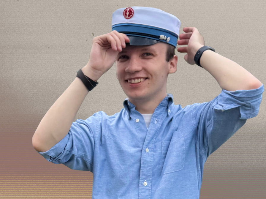 Jakob Manton i blå skjorte med studenterhue på